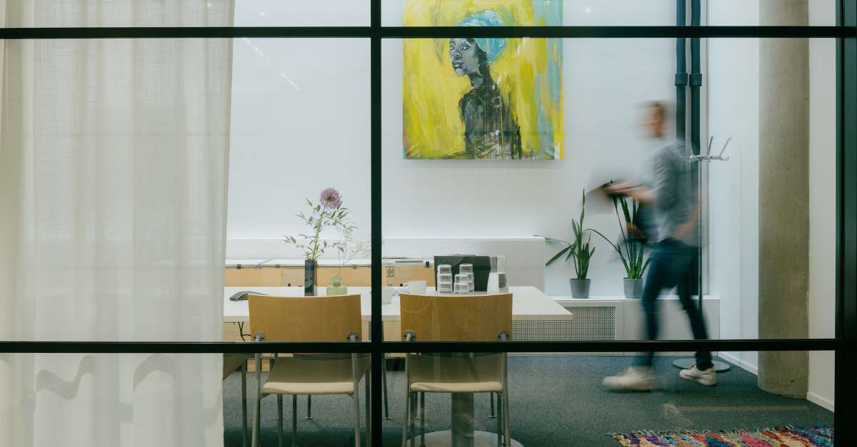 Kuva, jossa mies kävelee kokoustilaan
